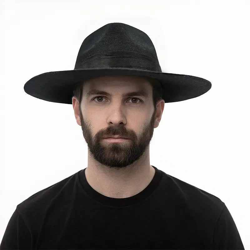 A black felt fedora worn by a man wearing a black shirt.
