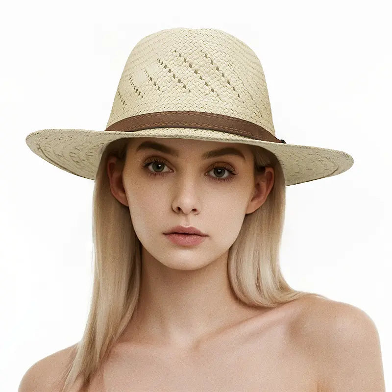 Woman with long blonde hair wearing a light beige woven straw hat with a brown band, set against a plain white background