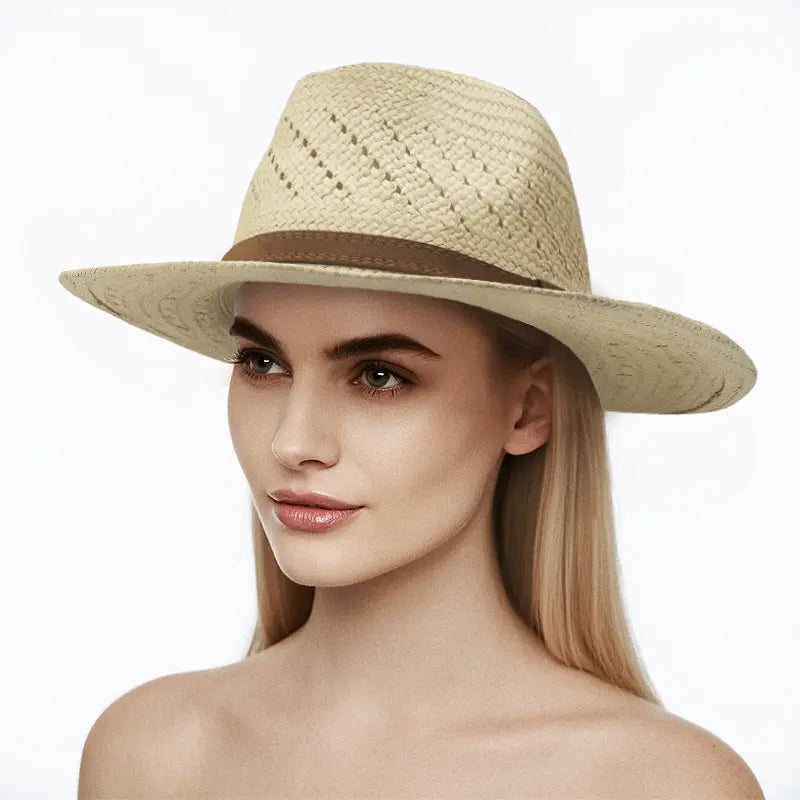 Woman with long blonde hair wearing a light beige woven straw hat with a brown band, set against a plain white background