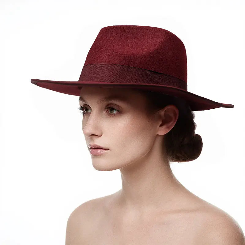 Woman with hair styled in a low bun, wearing a maroon wide - brimmed hat with a dark band around the crown