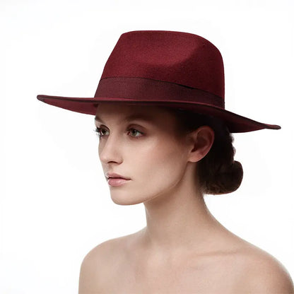 Woman with hair styled in a low bun, wearing a maroon wide - brimmed hat with a dark band around the crown