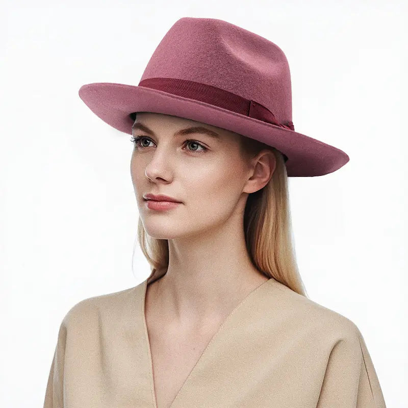 Dusty rose felt wide - brimmed hat with dark band, worn by a model.