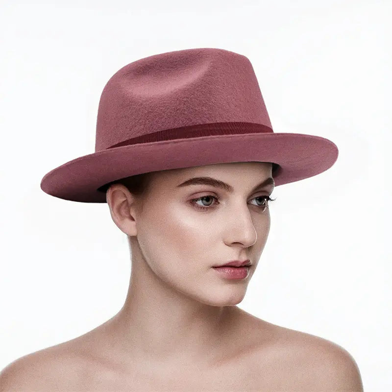 Dusty rose felt wide - brimmed hat with dark band, worn by a model.